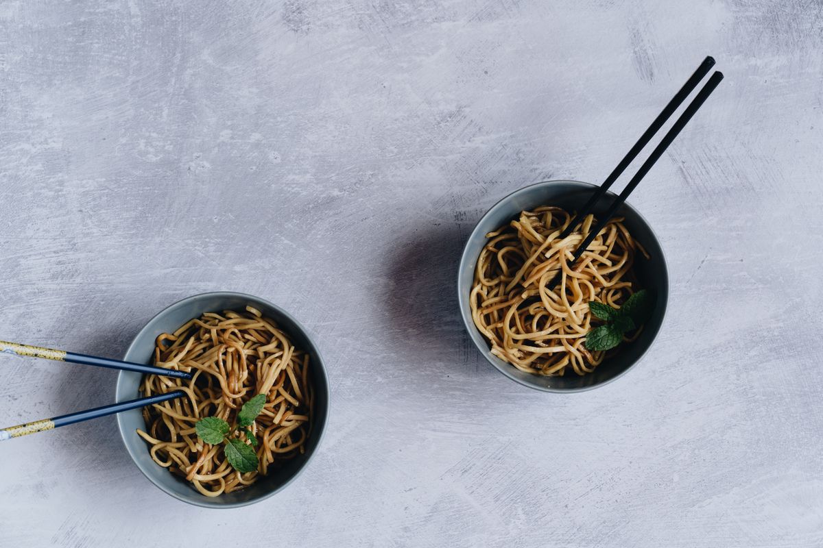 Asian-style noodle bowls garnished with fresh mint