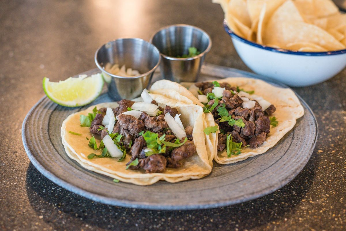 Authentic Mexican street tacos garnished with cilantro, onion, and lime