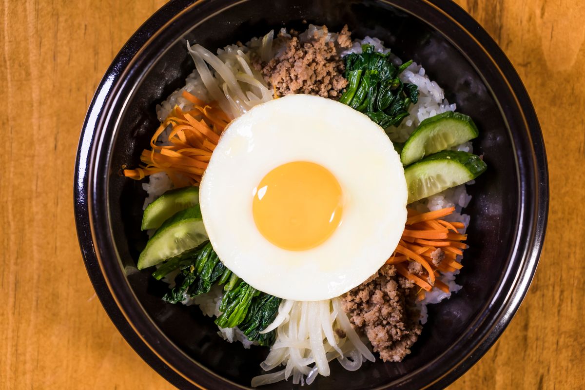 Korean bibimbap bowl with a fried egg, vegetables, and rice